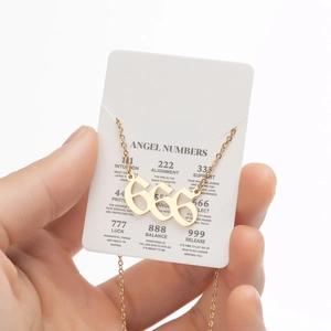 Vue détaillée du collier pendentif 666 doré avec sa carte de numéro d'ange