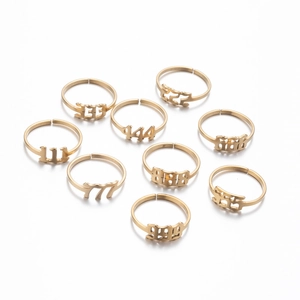 Flat lay of multiple 18K gold plated stainless steel angel number rings with open bands