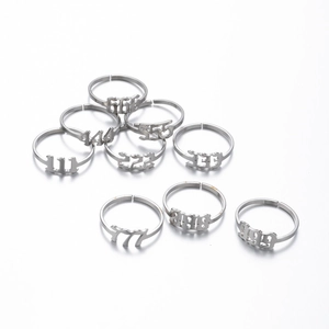 Detailed flat lay of nine adjustable stainless steel angel number rings from 111 to 999