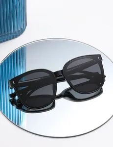 Close-up of black polarized sunglasses on reflective surface with detail of frame specs