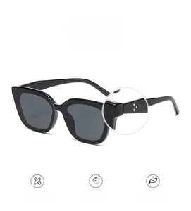 Vue détaillée des lunettes de soleil œil-de-chat noires avec rivets argentés et verres UV