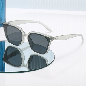 Lunettes de soleil polarisées œil de chat chic avec monture grise sur surface miroir