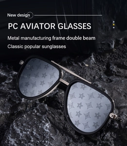 Close-up of aviator sunglasses with gold double bridge on textured black stone