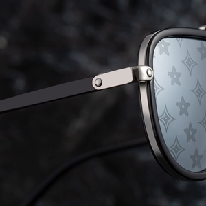 Detailed macro of metal hinge and star monogram pattern on blue lenses