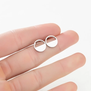 Detail showing hand holding geometric semi-circle stud earrings in polished silver finish