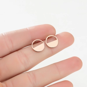 Detailed close-up of rose gold geometric semi-circle stud earrings with a polished finish