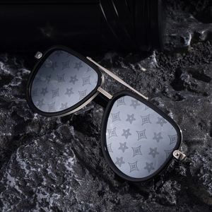 Retro pilot sunglasses featuring luxury star pattern lenses on textured dark rocks