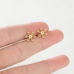 Detailed view of gold snowflake earrings with hollow six-pointed symmetrical design