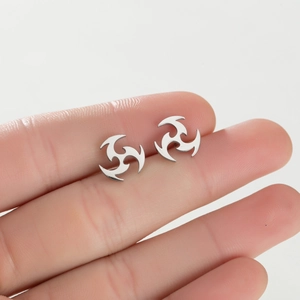 Détail macro de boucles d'oreilles tourbillon argentées en acier au design de vortex