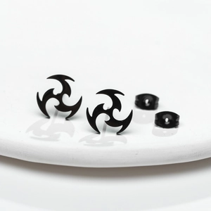 Vue macro de boucles d'oreilles noires tourbillonnantes plaquées or 18 carats sur plateau
