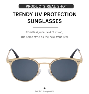 Close-up of golden metal frame sunglasses with UV protection and deep gray lenses