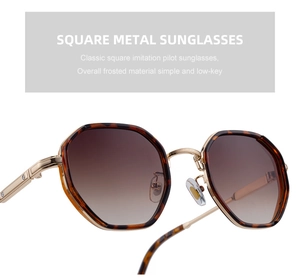 Detail of octagonal tortoiseshell sunglasses with gold metal frame and gradient brown lenses