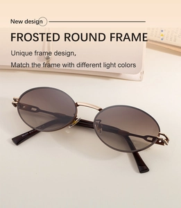 Detail view of oval sunglasses with bronze metal frame and brown gradient lenses