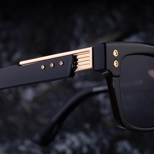 Macro shot of durable golden hinge and hexagonal screw on square black sunglasses