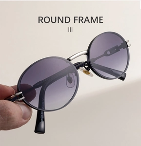 Close-up of retro oval sunglasses featuring black frames and purple gradient lenses