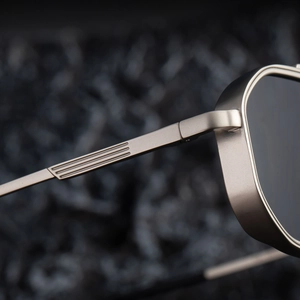 Détail macro de lunettes de soleil carrées gris métal avec branches décorées