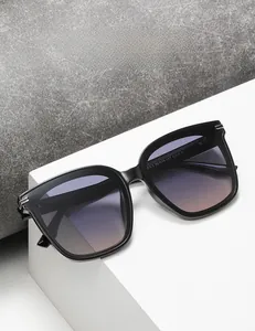 Gros plan sur lunettes de soleil carrées noires avec verres dégradés violet-orange