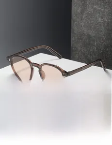 Close-up of retro square sunglasses with transparent brown frame and metal rivet details
