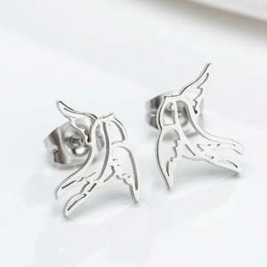 Macro shot of silver swallow bird stud earrings in minimalist polished stainless steel