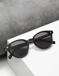 Detail of retro black sunglasses with silver wing hardware and high-quality gray lenses