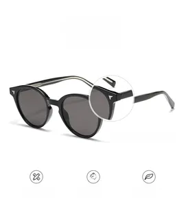 Macro detail of black round sunglasses showing silver wing metal hinge decoration