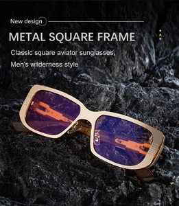 Detail eines quadratischen Goldmetallrahmens mit blau-violetten Gläsern vor Felsenhintergrund