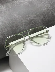Detail of pilot sunglasses with green frames and metal temples on a geometric stand