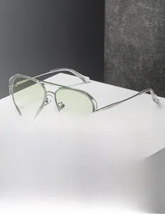 Detail of transparent aviator sunglasses with green lenses on a white platform