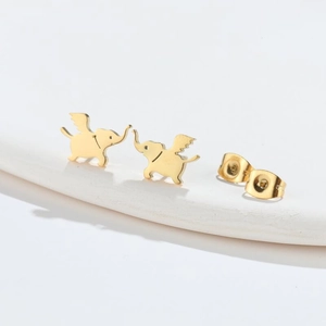 Vue macro de boucles d'oreilles éléphant à ailes dorées avec fermoirs papillon