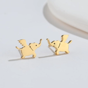 Détail macro de boucles d'oreilles éléphant ailé doré avec finition métallique polie