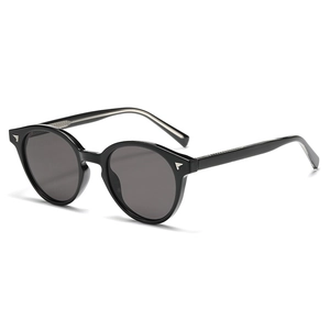 Retro black round sunglasses with dark grey lenses and silver wing studs on a white background