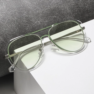 Modern pilot sunglasses with transparent green frames and silver metal temples on display