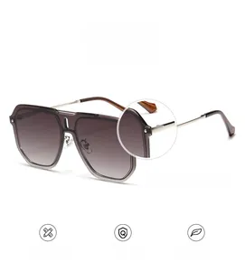 Detail of square pilot sunglasses featuring translucent grey frames and gold metal hinges