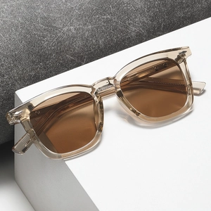 Lunettes de soleil rétro avec monture marron transparente et verres teintés sur pierre