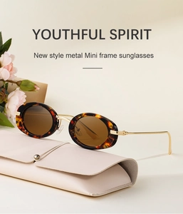 Retro tortoiseshell oval sunglasses with gold metal temples on a leather case