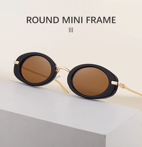 Detailed close-up of retro oval mini sunglasses with black thick frames and gold metal bridge