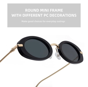 Detail of oval sunglasses with thick black PC frames and slim gold metal temples