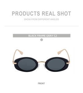 Detailed front view of black oval sunglasses with golden metal bridge and gray lenses