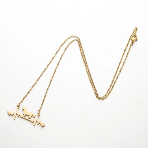 Detailed view of golden horse silhouette and heartbeat pendant with lobster clasp