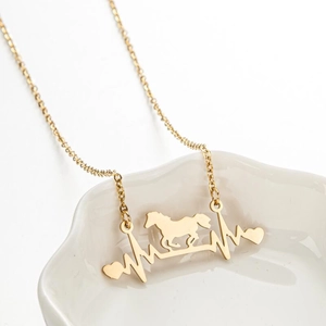 Golden stainless steel necklace featuring a running horse and heartbeat pendant on white plate