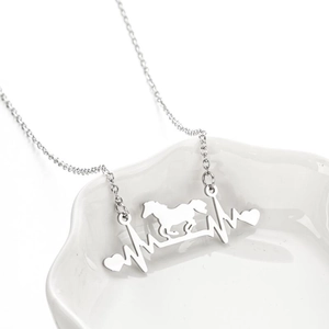Minimalist silver heart heartbeat necklace with horse pendant on white ceramic plate