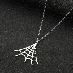 Macro shot of silver spider web pendant on a black textured background with thin chain