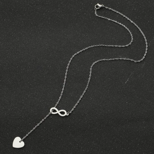 Collier minimaliste argenté avec pendentif infini et cœur sur fond noir élégant