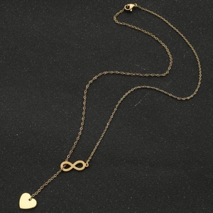 Collier doré pour femme avec pendentif infini et cœur sur fond noir avec fermoir mousqueton