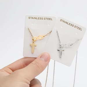 Detail of stainless steel cross and infinity symbol pendant necklaces in gold and silver