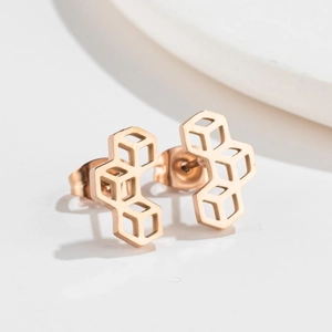 Macro shot of rose gold geometric hollow hexagon stud earrings with butterfly backings