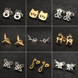 Detail view of animal stud earrings in gold and silver finish on textured background