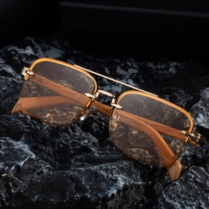 Retro rimless sunglasses with light brown lenses and wood grain temples on volcanic rock