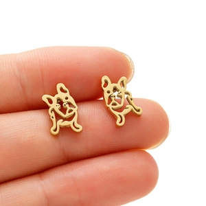 Boucles d'oreilles bouledogue français doré tenues par les doigts pour la taille