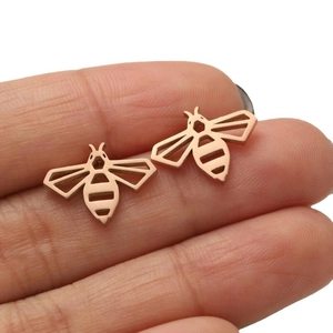 Minimalist rose gold hollow bee stud earrings in stainless steel held in hand